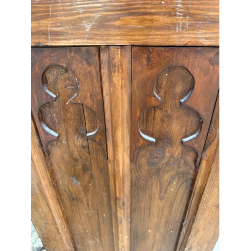 134 - An oak four seater church pew with gothic carved panels and scrolling arms H90cm W260cm D39cm