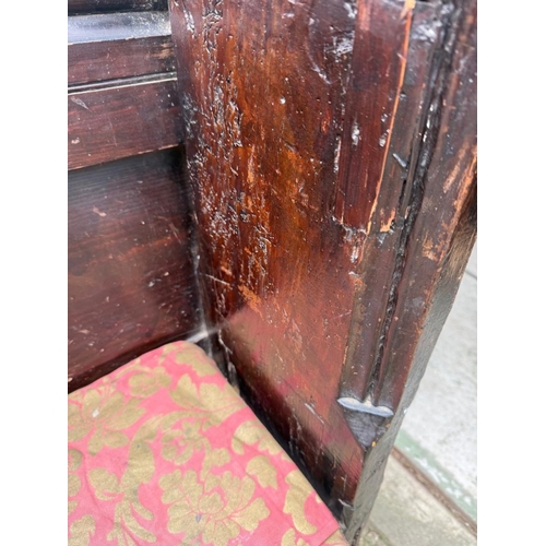 136 - An oak church pew with paneled back and carved ornamental ends H123cm W228cm D33cm