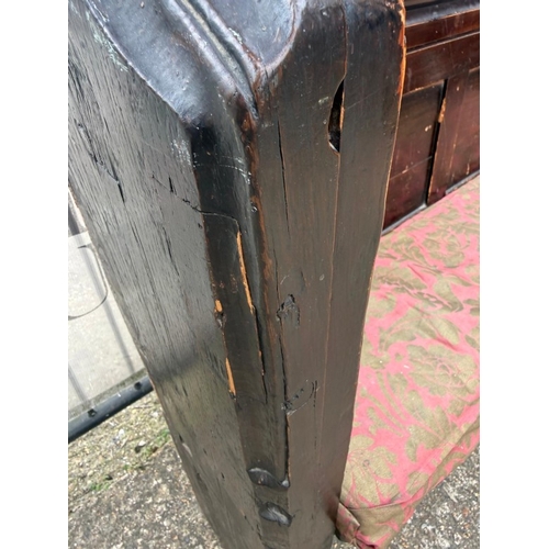 136 - An oak church pew with paneled back and carved ornamental ends H123cm W228cm D33cm