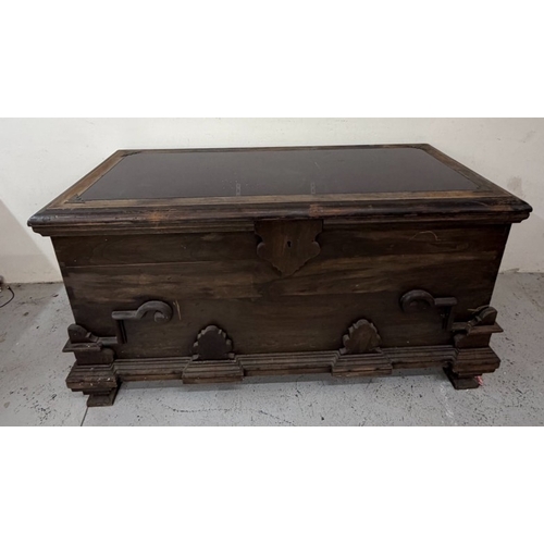 150 - A hardwood storage trunk with carved detail to the side and a glazed lid opening to a selection inte... 