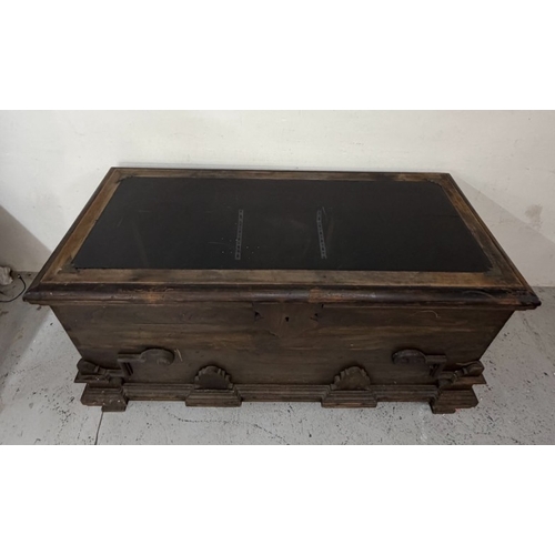 150 - A hardwood storage trunk with carved detail to the side and a glazed lid opening to a selection inte... 