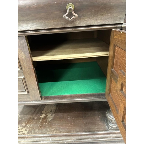 151 - A Jacobean style oak sideboard featuring two drawers over two cupboards H95cm W197cm D65cm