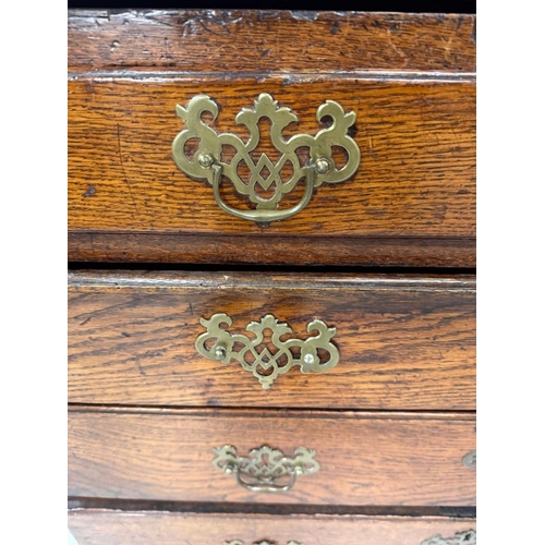 154 - An oak four drawer bureau with brass handles, the fall opening to pigeon holes and drawers H107cm W9... 