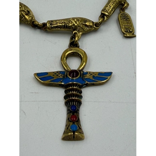 173 - An enamel and gilt metal Egyptian Revival necklace, suspending Egyptian sphinx, hieroglyphics and ch... 