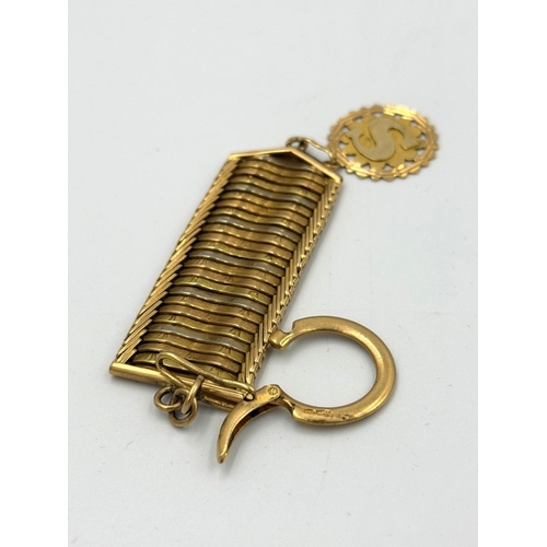 577 - An Arabian three colour gold key ring with an embossed S pendant.