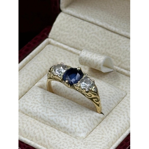 592 - A Sapphire ring with diamonds either size, on an 18ct gold setting, size K