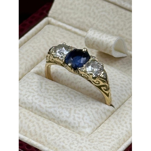 592 - A Sapphire ring with diamonds either size, on an 18ct gold setting, size K