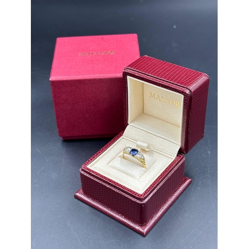 592 - A Sapphire ring with diamonds either size, on an 18ct gold setting, size K