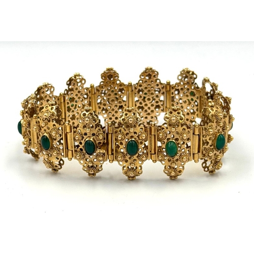 600 - A fabulous Arabian gold and green stone ornate bracelet with filigree panels each set with a green s... 