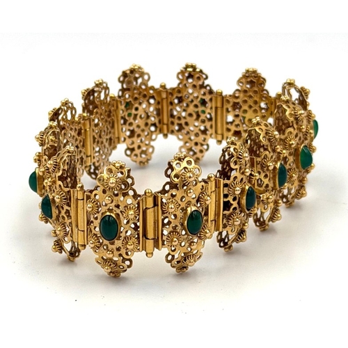 600 - A fabulous Arabian gold and green stone ornate bracelet with filigree panels each set with a green s... 