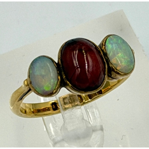 602 - A 22ct gold three stone ring with central garnet and two opals, approximate weight 4.5g and size P