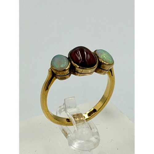 602 - A 22ct gold three stone ring with central garnet and two opals, approximate weight 4.5g and size P