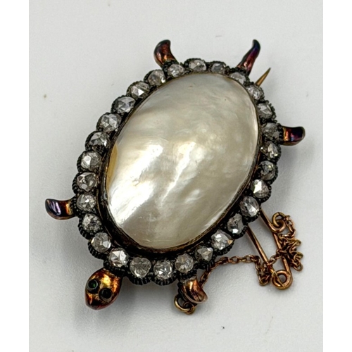 606 - An antique tortoise brooch with marbe pearl body set in 18ct gold, the body is surrounded by rose cu... 