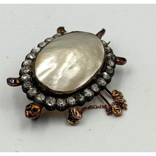 606 - An antique tortoise brooch with marbe pearl body set in 18ct gold, the body is surrounded by rose cu... 