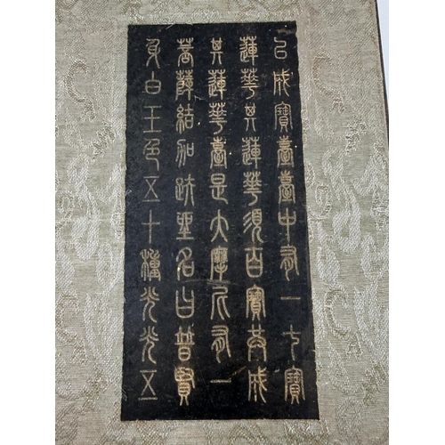 A Chinese wood and fabric bound book containing black hard stone ...