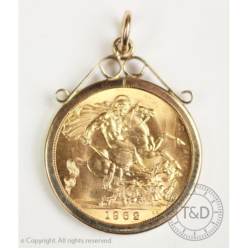 129 - An Elizabeth II gold sovereign dated 1962, within a 9ct gold mount, gross weight 9.4gms