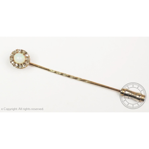 211 - An opal and diamond set stick pin, designed as a central oval opal, within a surround of twelve rose... 