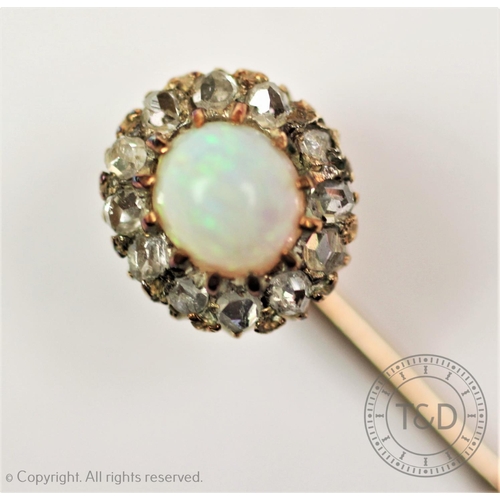 211 - An opal and diamond set stick pin, designed as a central oval opal, within a surround of twelve rose... 