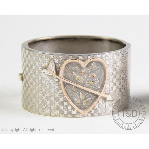 254 - A Victorian sentimental bangle, the half hinged bangle designed as a gilt relief heart design with p... 