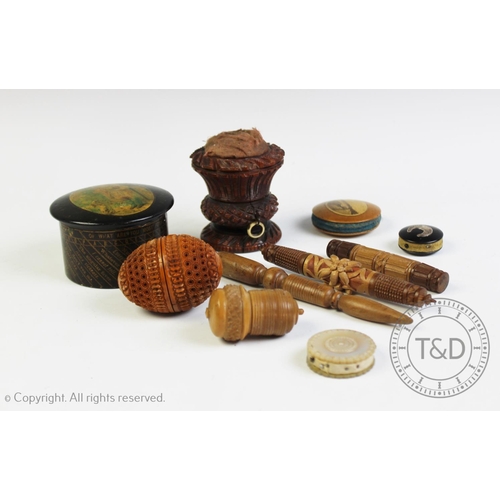 309 - A selection of carved sewing items, to include; a coquilla nut bobbin case, 7cm high, a carved wood ... 