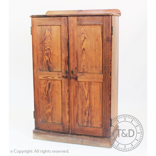 948 - A Victorian pitch pine two door cupboard, the pair of panelled doors applied with knob handles enclo... 