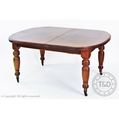 949 - An Edwardian oak extending dining table, with rounded corners and raised on turned and fluted legs, ... 