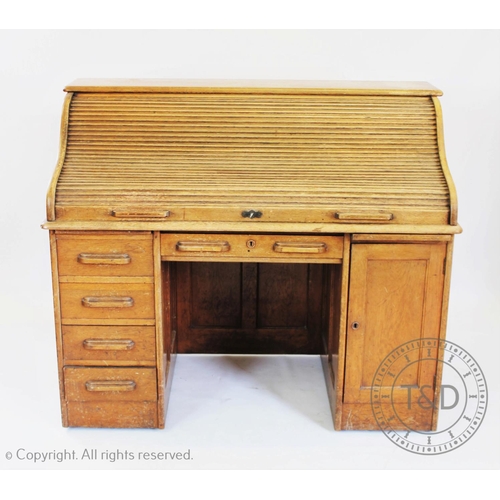 950 - An Edwardian golden oak roll top desk, with tambour front over five drawers and a cupboard door 115c... 