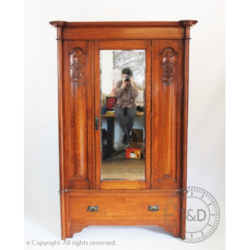 955 - An Art Nouveau oak bedroom suite comprising; a single door wardrobe and a mirror back dressing chest... 