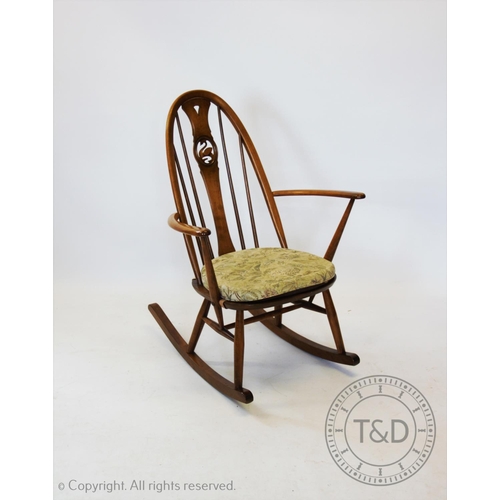 959 - An Ercol stained beech wood rocking chair, the hoop back centred with a carved swan motif, 91cm