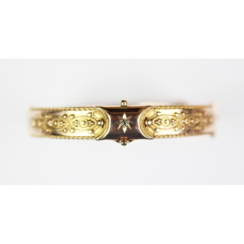 224 - A Victorian 9ct gold hinged bangle, Birmingham 1870, designed as a central claw set, old cut diamond... 