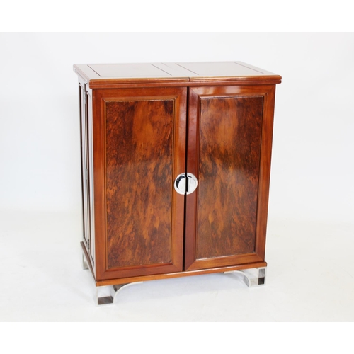 967 - An Art Deco style hardwood drinks bar, the rectangular folding bar top above two cupboard doors encl... 