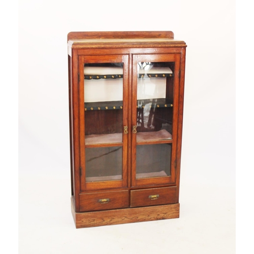 953 - An Edwardian oak two door bookcase, with two glazed doors and two drawers below,137cm H x 79cm W x 2... 