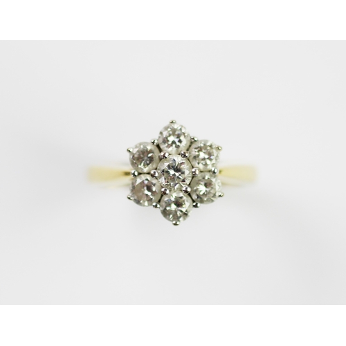 285 - A diamond set cluster ring, designed as a central claw set brilliant cut diamond, in a surround of s... 