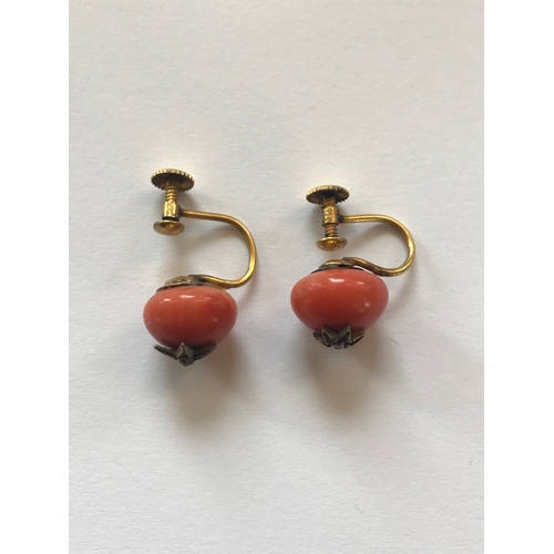 194 - A pair of coral set drop earrings, each of pendeloque drop form and with yellow metal fittings, with... 