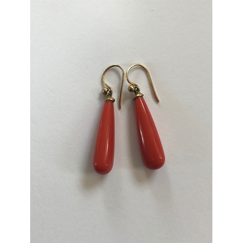 194 - A pair of coral set drop earrings, each of pendeloque drop form and with yellow metal fittings, with... 