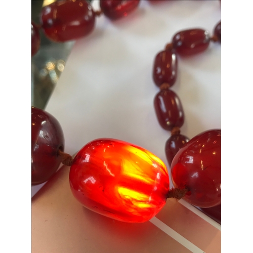 222 - A 'Cherry' amber single strand bead necklace, the forty seven graduated beads, (largest measuring 2.... 