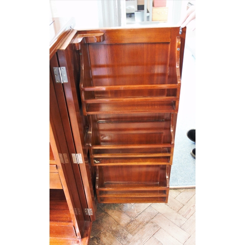 967 - An Art Deco style hardwood drinks bar, the rectangular folding bar top above two cupboard doors encl... 