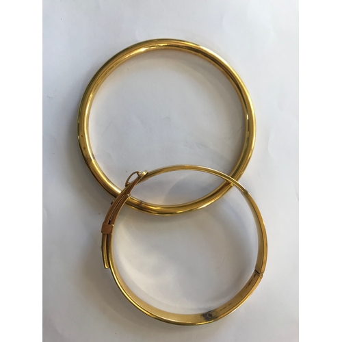 257 - A 9ct yellow gold slave bangle, 10cm diameter, weight 16.8gms, along with another similar example of... 