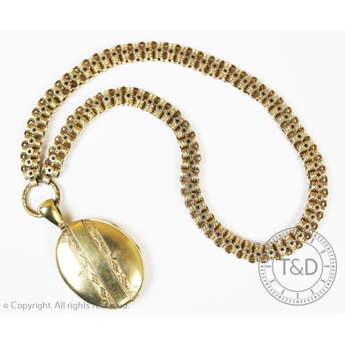 165 - A Victorian gilt metal locket pendant, oval form with engraved monogram and pattern to exterior, att... 