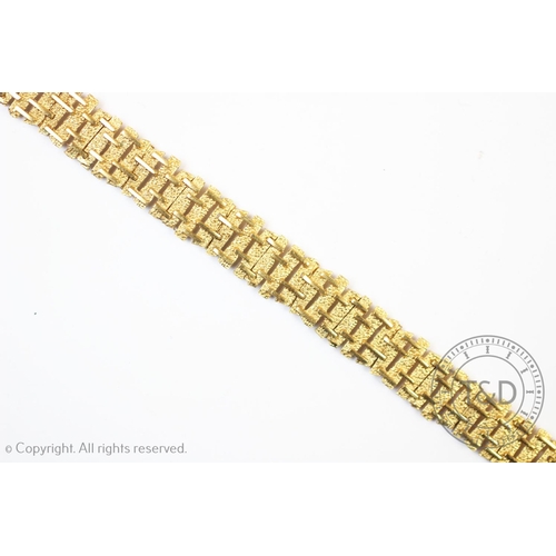 182 - A 9ct gold line bracelet of abstract textured form, London 1971, 1.1cm wide, 17cm long, tongue and b... 