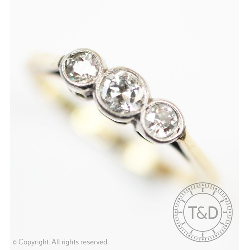 232 - A three stone diamond ring, the three graduated diamonds each collet set in white metal, to the tape... 