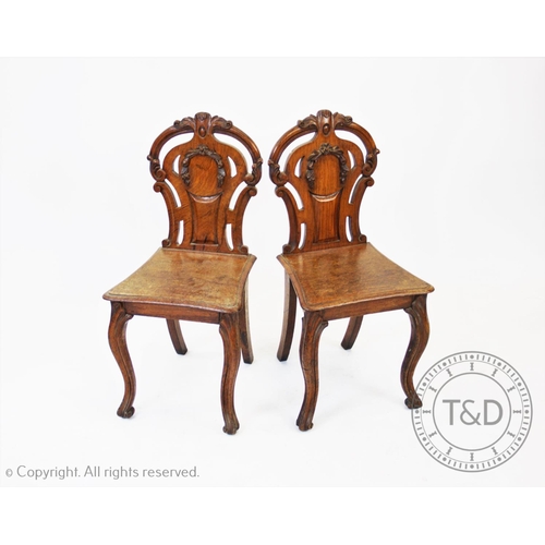 778 - A pair of Victorian oak and pollard oak hall chairs, each chair with an open work back of waisted fo... 