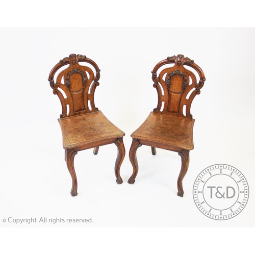 778 - A pair of Victorian oak and pollard oak hall chairs, each chair with an open work back of waisted fo... 