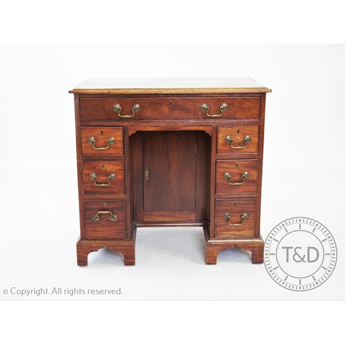 785 - An early 19th century mahogany knee hole desk, with an arrangement of seven drawers around a central... 