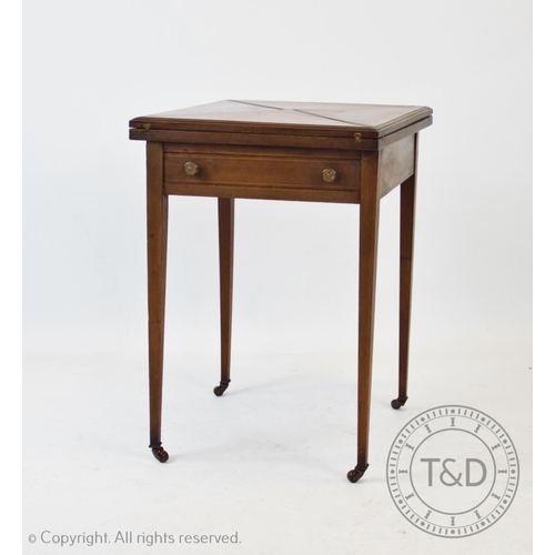 799 - An Edwardian mahogany envelope games table, the square folding top above a single frieze drawer, rai... 