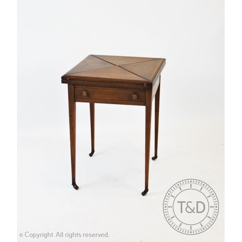 799 - An Edwardian mahogany envelope games table, the square folding top above a single frieze drawer, rai... 