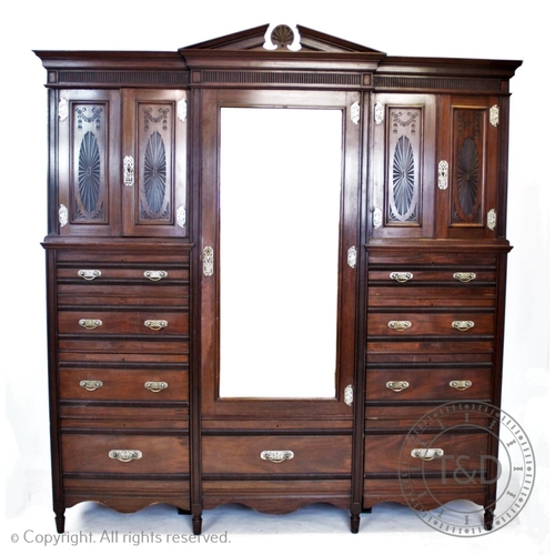 807 - An Edwardian walnut compactum wardrobe in the aesthetic style, by Lamb of Manchester, having an arch... 