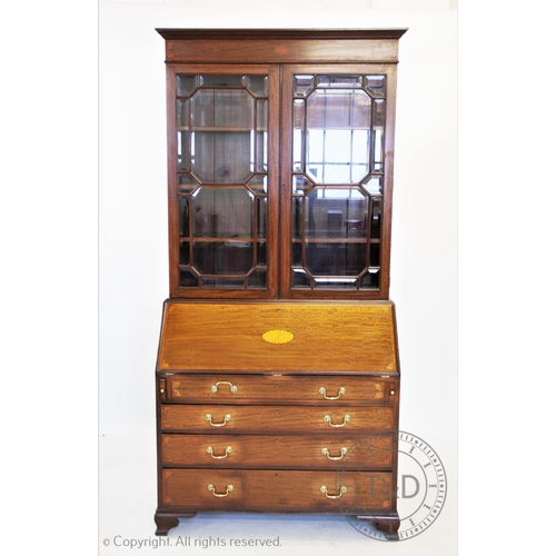 810 - An Edwardian inlaid mahogany Sheraton revival bureau bookcase, having a moulded cornice above an inl... 