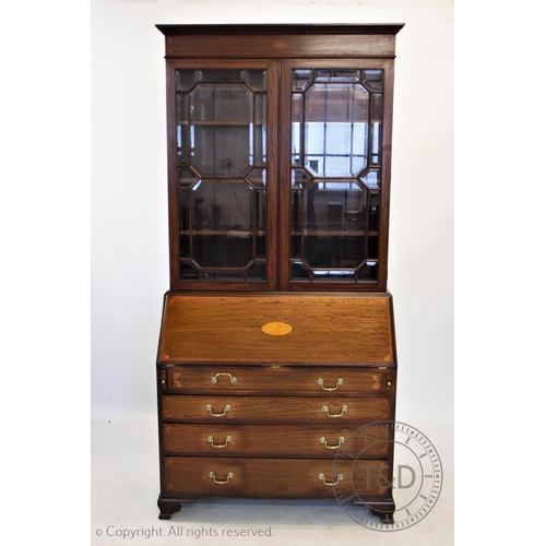 810 - An Edwardian inlaid mahogany Sheraton revival bureau bookcase, having a moulded cornice above an inl... 