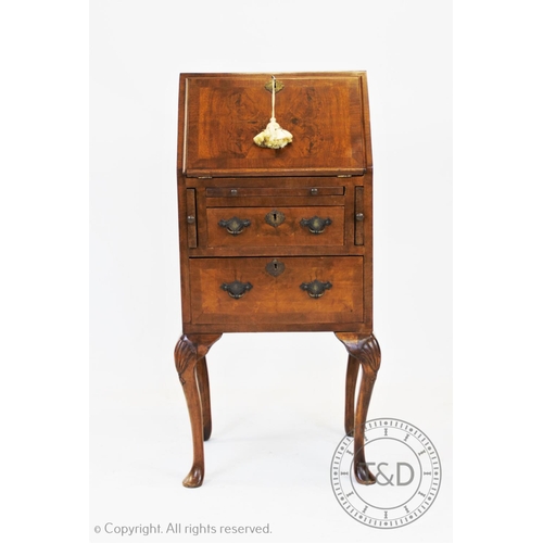 821 - A George II style ladies walnut bureau, 20th century, the cross banded fall front enclosing a compar... 